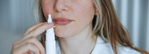Mulher usando spray nasal